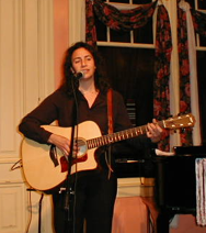Devra Wolf performing with acoustic guitar